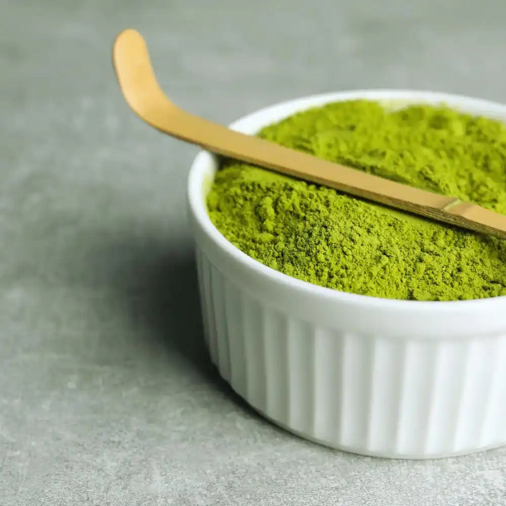 Cucharilla chashaku de bambú sobre cuenco lleno de matcha