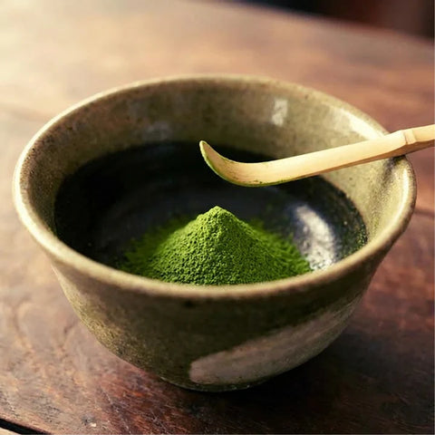 Matcha en polvo en un cuenco con cuchara de bambú.
