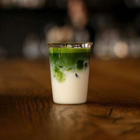 Matcha latte frío con leche y hielo preparado con té matcha