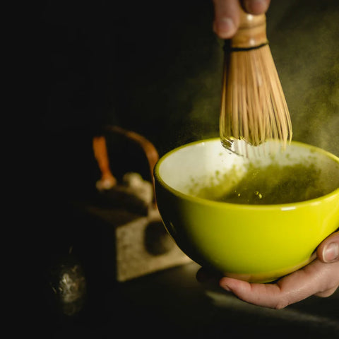 Preparación de té matcha con chasen batiendo el matcha en un cuenco
