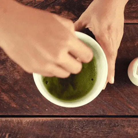 Preparando té matcha en un cuenco desde arriba.